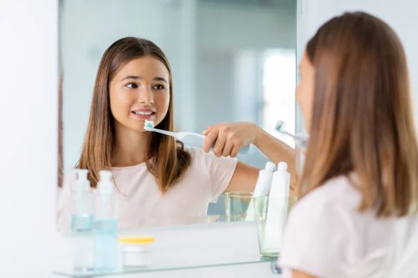 Woman brushing teeth properly with angled brush